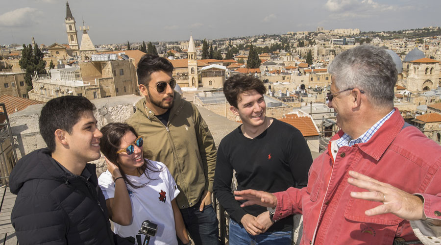 A Suffolk professor talks to a group of students during a trip to Israel.