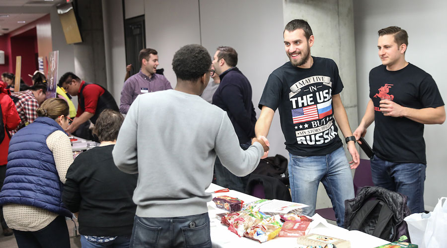 Two Suffolk students shake hands during Suffolk International Night.