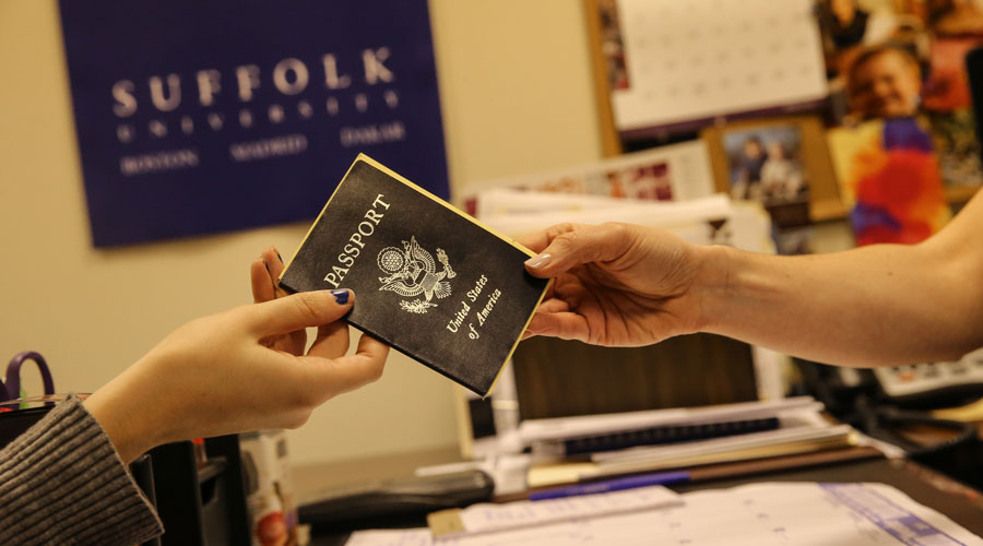 A Suffolk student hands over their passport in the study abroad office.