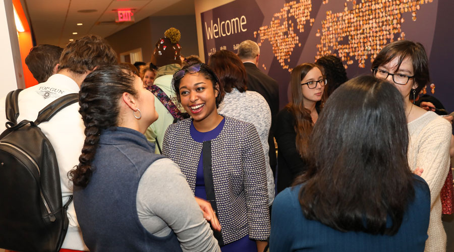 A group of INTO Suffolk students and faculty talk with one another.