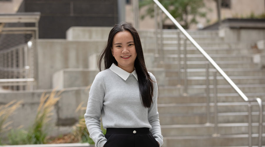 An INTO Suffolk student poses for a portrait on campus.