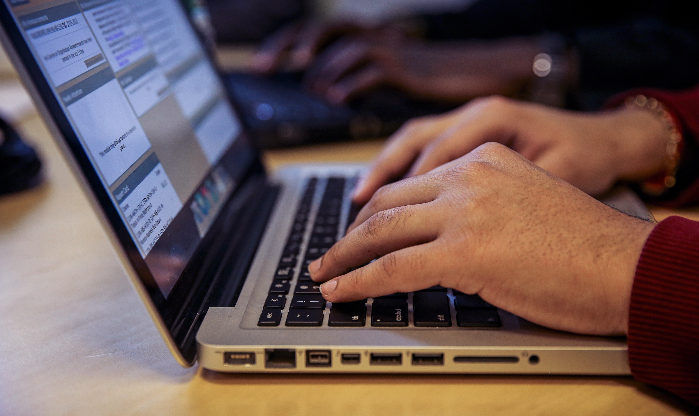 A closeup image on someone's hands working at a laptop computer.
