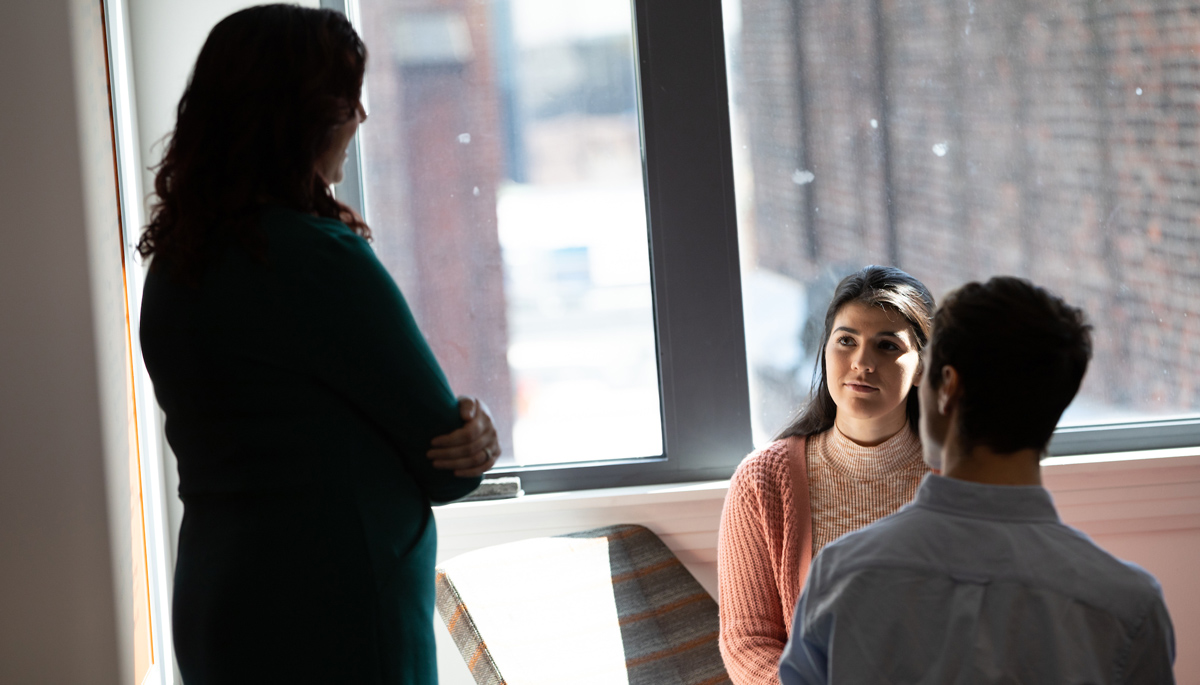 Brianna Vieira working with a professor and another student in Sargent Hall