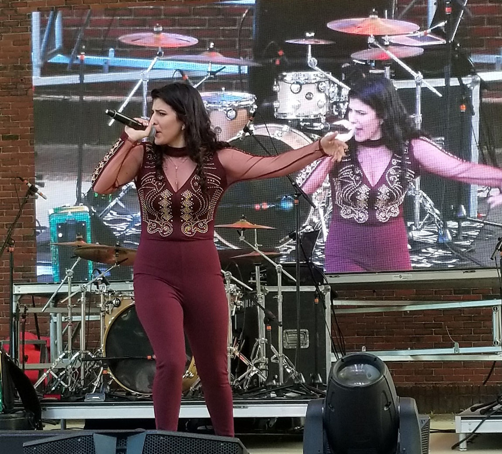 Brianna Vieira performing one of her songs for a crowd