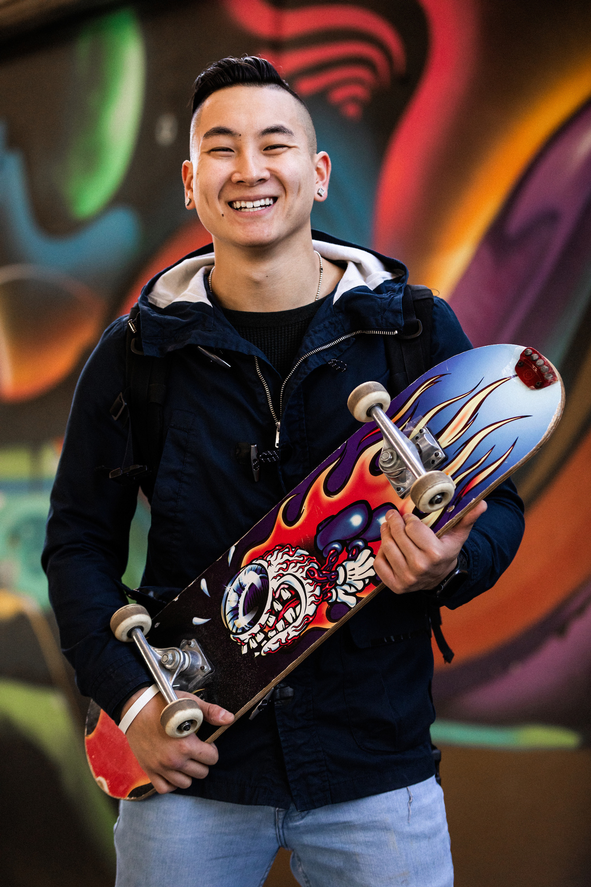 Dan Redznak holding a skateboard and smiling.