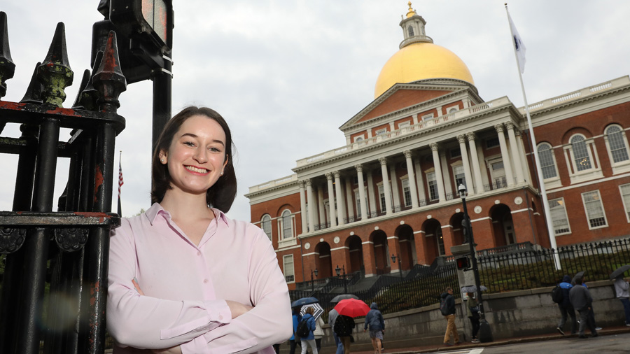 Maggie Randall posing for a portrait outside the Massachusetts State House.