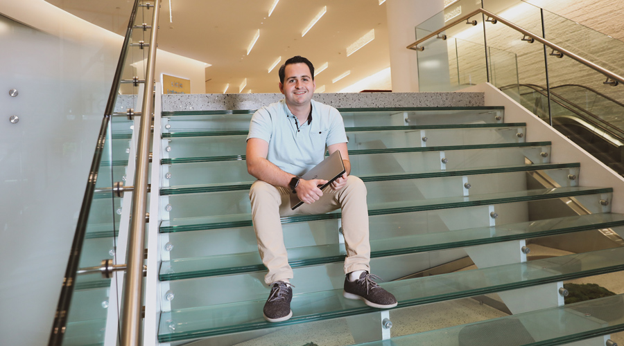 Vincent LePore sits on the stairs instead his company's coworking space.
