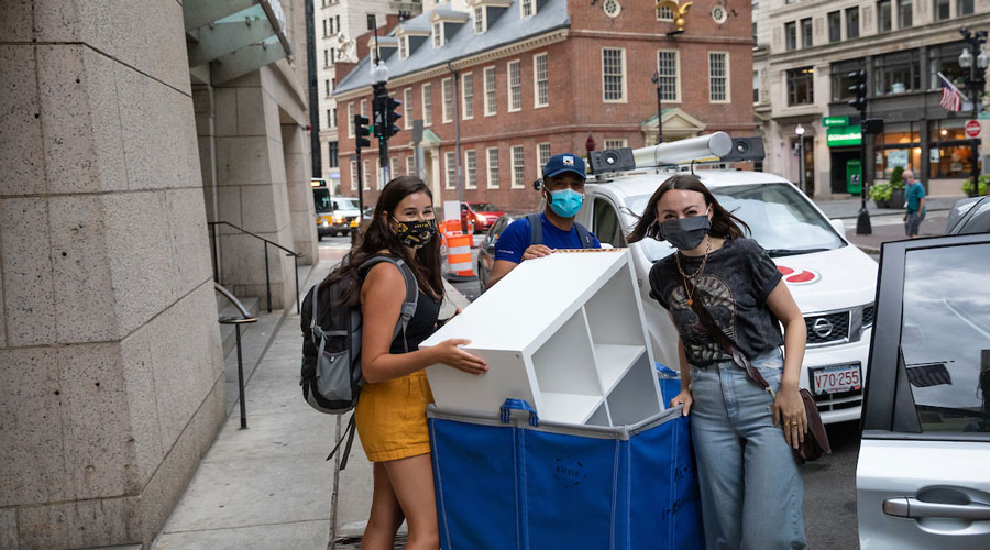 Suffolk students pushing a cart full of belongings into One Court Street on move-in weekend.