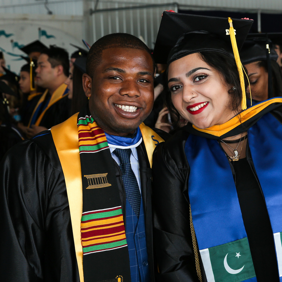 Isaac smiling with a friend at Commencement.