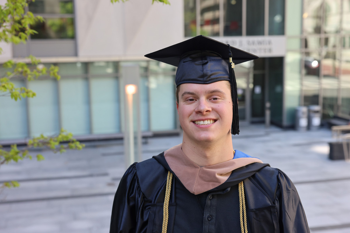 Portrait of Suffolk student Cameron in his cap and gown.