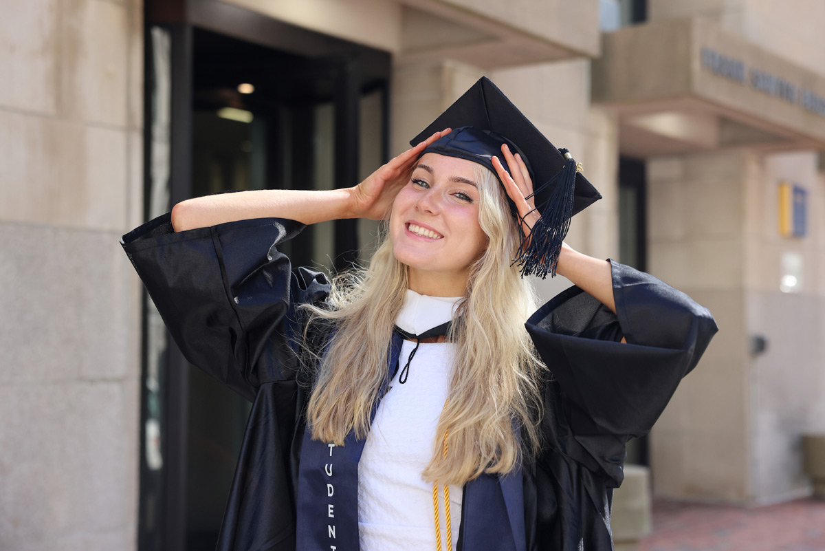 Portrait of Suffolk student Julia in her cap and gown.