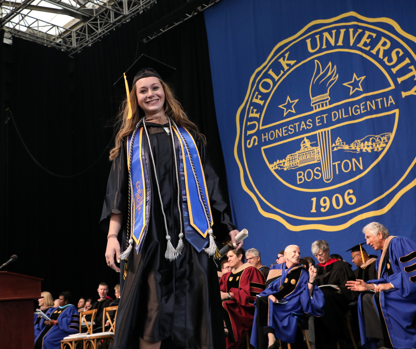 Morgan pauses while walking across the stage at Commencement to smile for the camera.