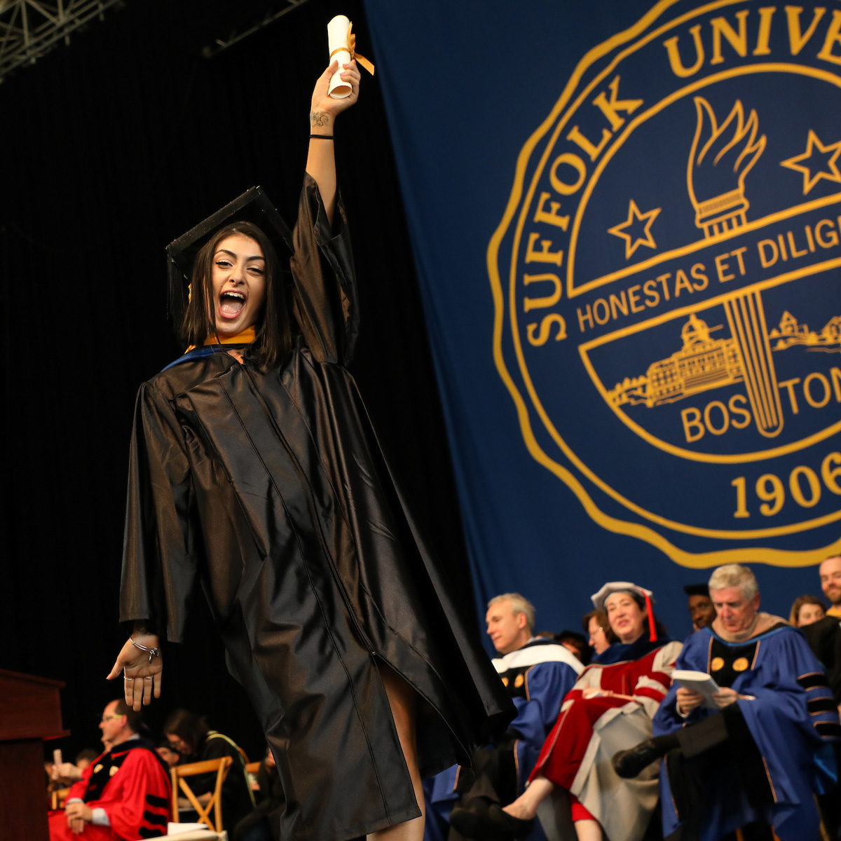 Olivia LeDonne holds up her scroll on stage during Commencement.