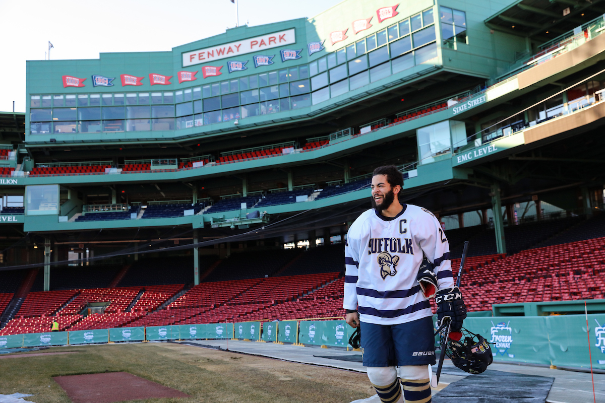 The captain of the Suffolk Men's Hockey Team walking onto the ice rink in Fenway Park for a special exhibition game.