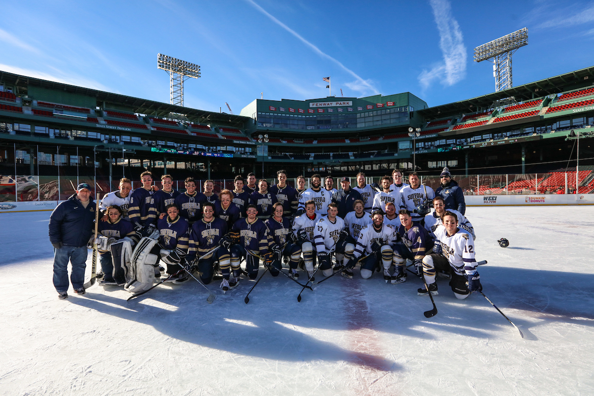 The Suffolk Men's Hockey team poses for a picture at center ice after a special exhibition game inside Fenway Park.