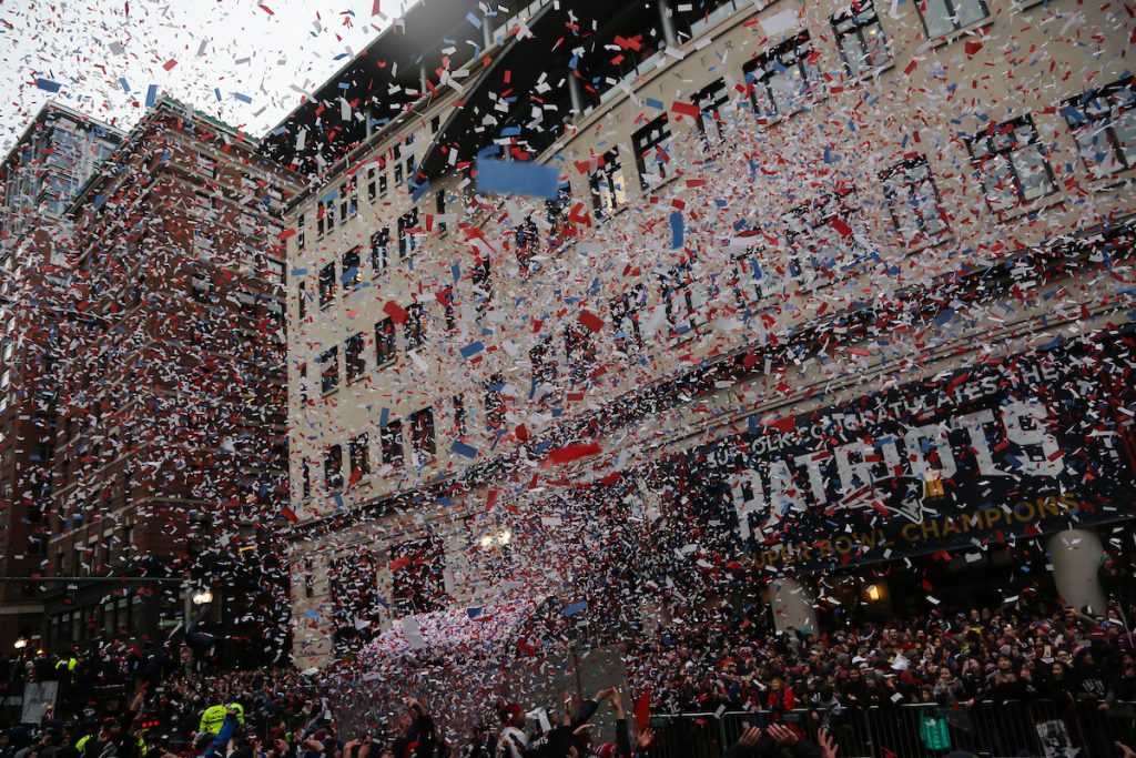 Confetti falls from the sky in front of Suffolk University's Sargent Hall during the New England Patriots Super Bowl victory parade.