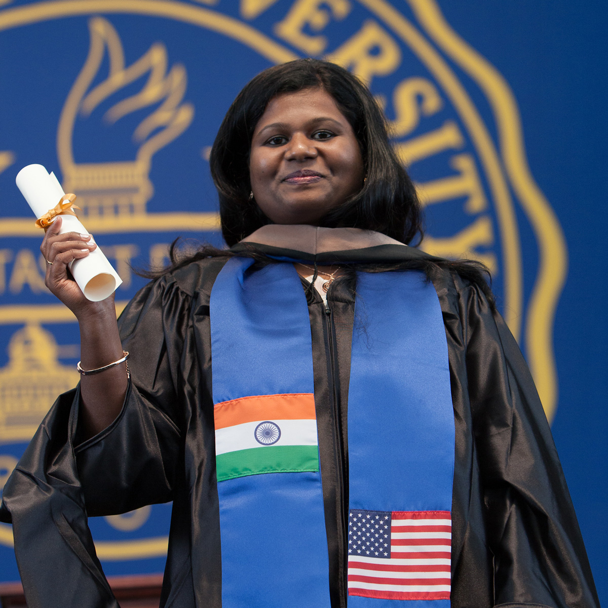 Annapoorani holding her scroll at her Commencement ceremony.