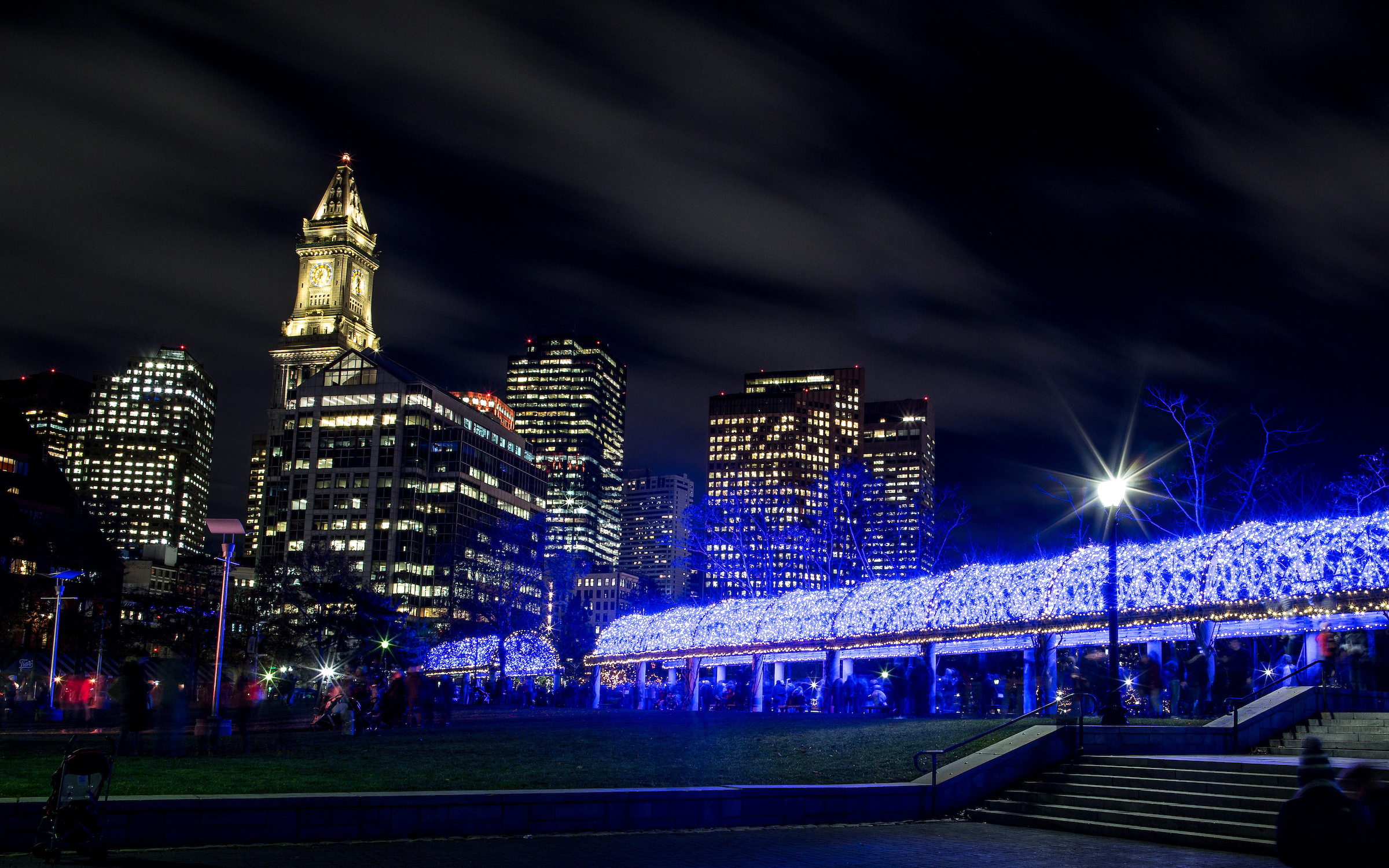 Christopher Columbus Waterfront Park on the Boston Harbor waterfront illuminated from blue lights for the holiday season.