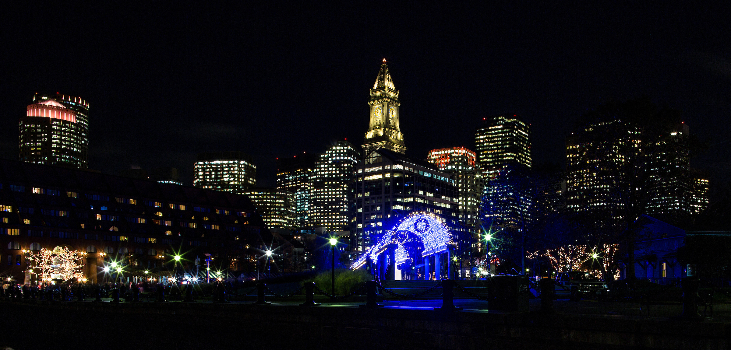 Christopher Columbus Waterfront Park on the Boston Harbor waterfront illuminated from blue lights for the holiday season.