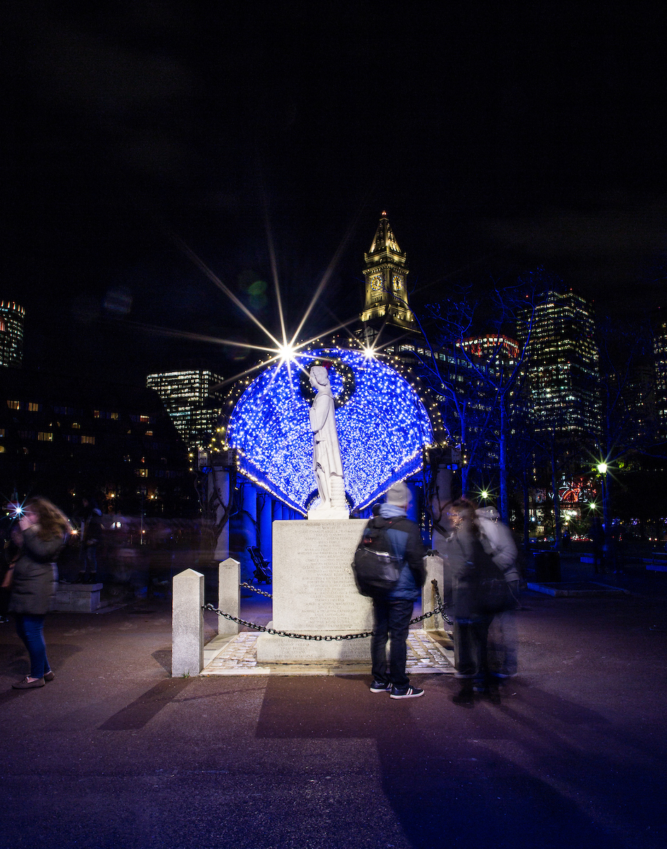 Christopher Columbus Waterfront Park on the Boston Harbor waterfront illuminated from blue lights for the holiday season.
