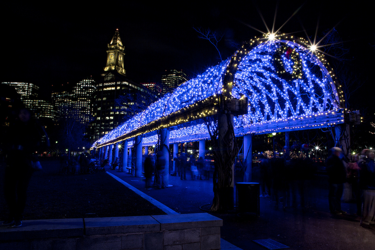 Christopher Columbus Waterfront Park on the Boston Harbor waterfront illuminated from blue lights for the holiday season.