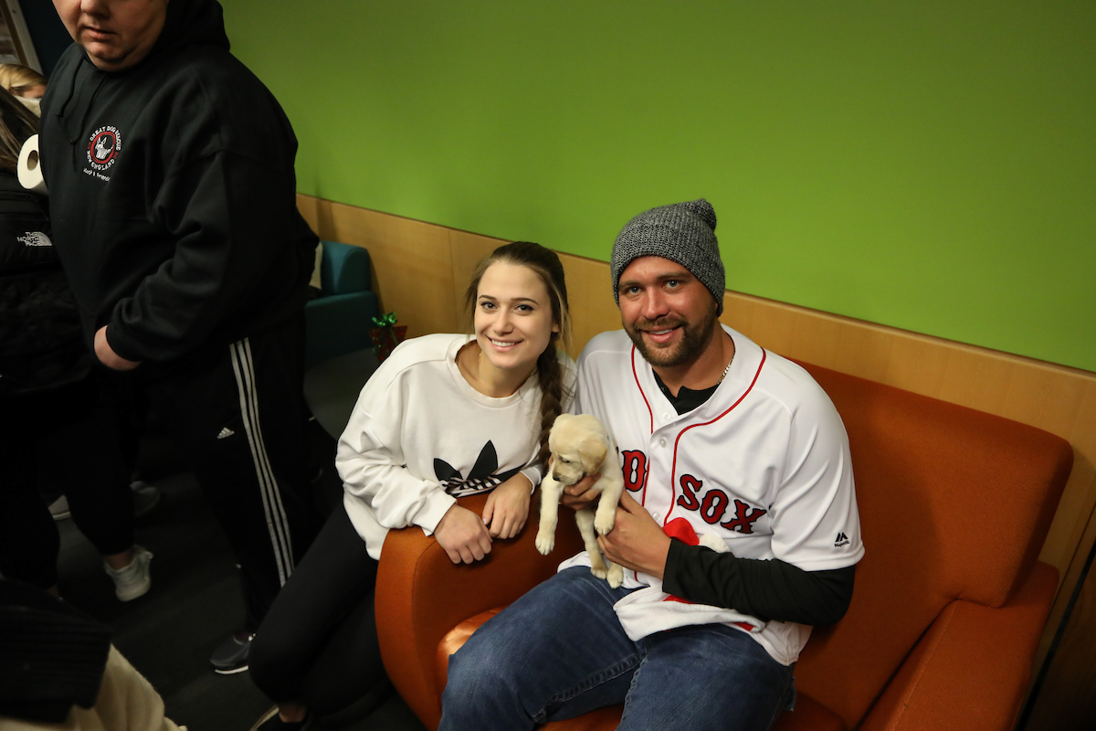 The Boston Red Sox visited Suffolk students with puppies the day before final exams begin.