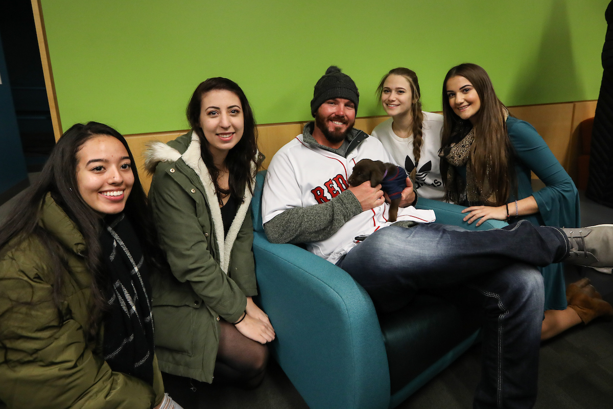 The Boston Red Sox visited Suffolk students with puppies the day before final exams begin.