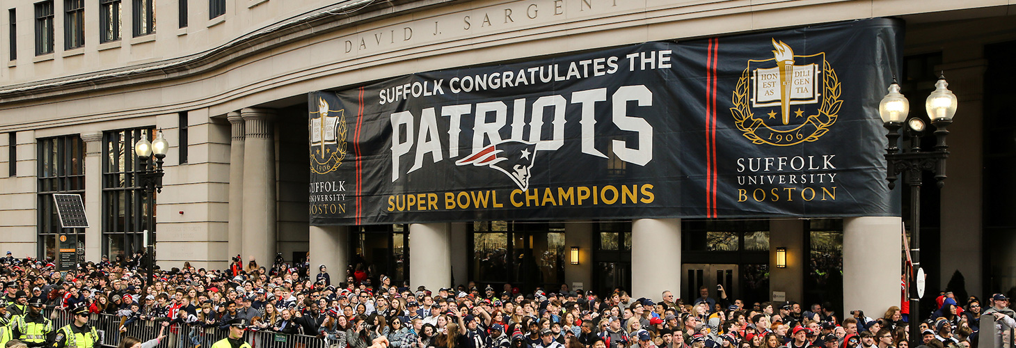 Suffolk University building with Patriots Parade in foreground.