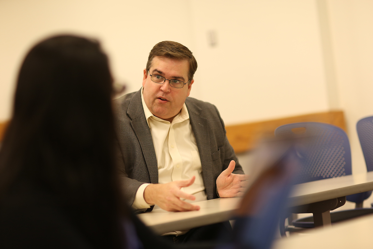 Suffolk professor George Moker discussing a topic with a student.