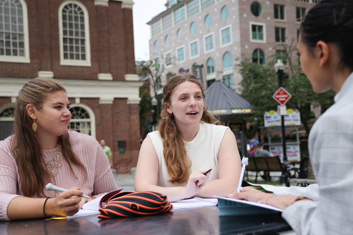 Suffolk student Chloe talks with two friends in Faneuil Hall.
