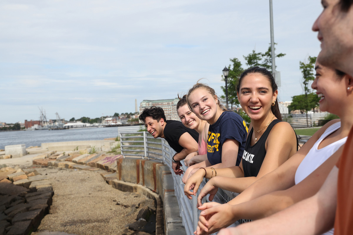 Suffolk students laughing together while taking in the Boston skyline from East Boston.