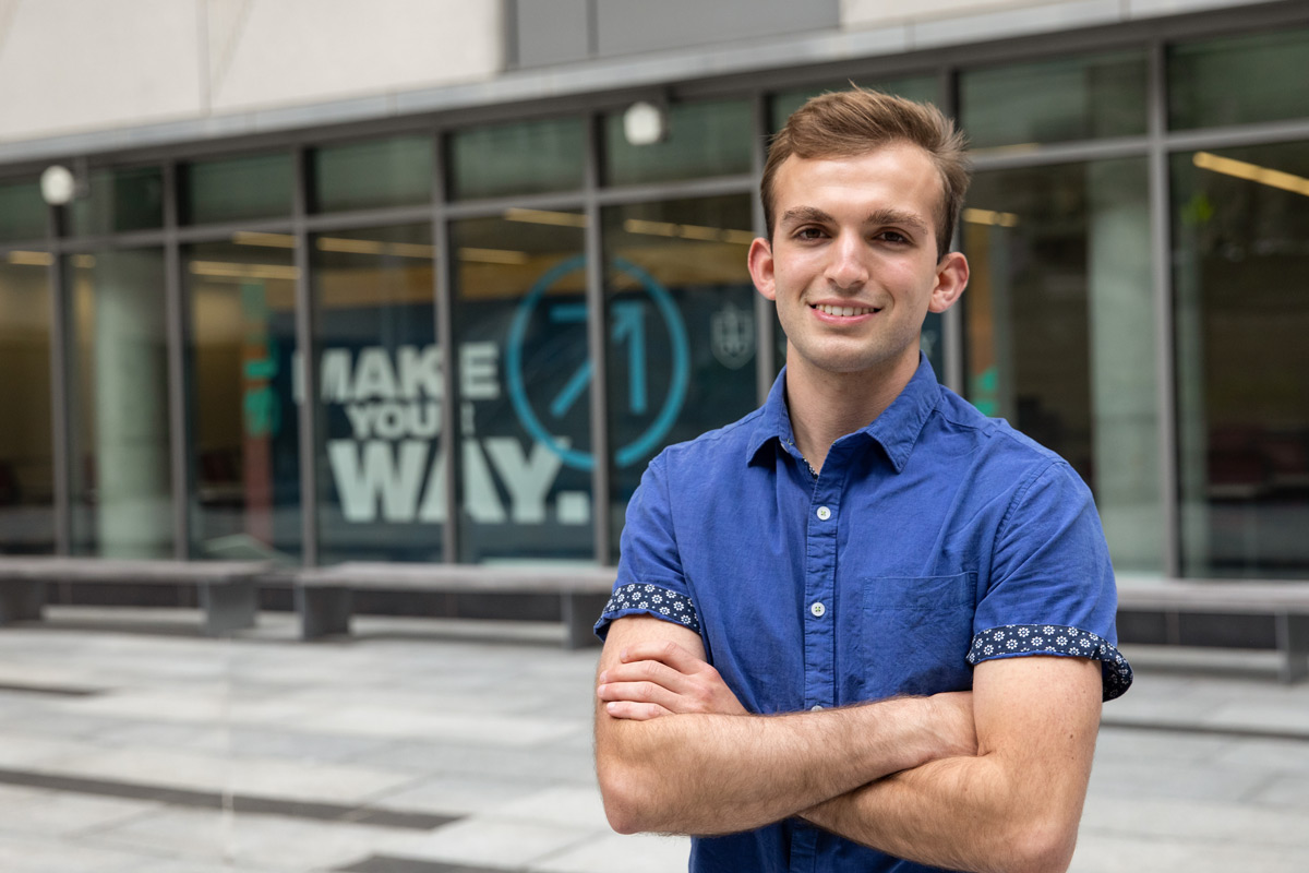 Suffolk student Nic poses for a photo outside the Samia Academic Center in Boston.