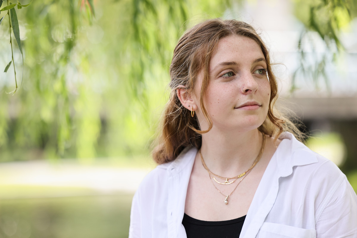 Suffolk student Chloe poses for a portrait at the Charles River Esplanade in Boston.