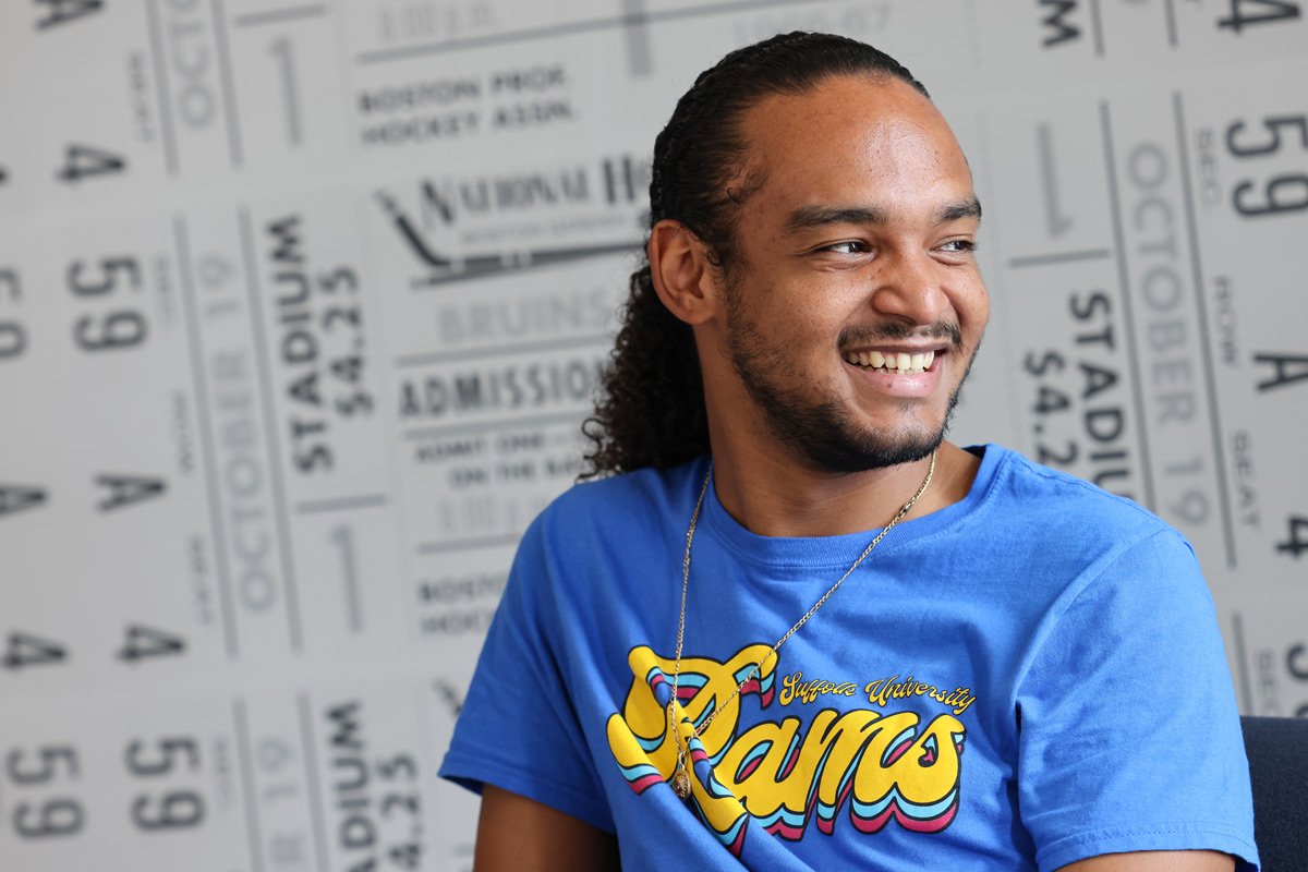 Suffolk student Omar poses for a portrait in the Bobby Orr Room in the One Court Street residence hall.