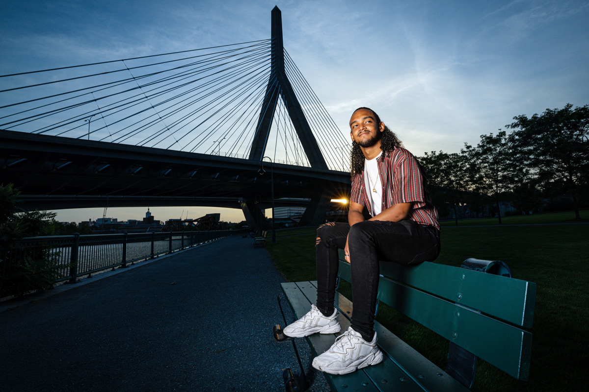 Suffolk student Omar poses for a portrait sitting on a bench in Paul Revere Park in Boston.
