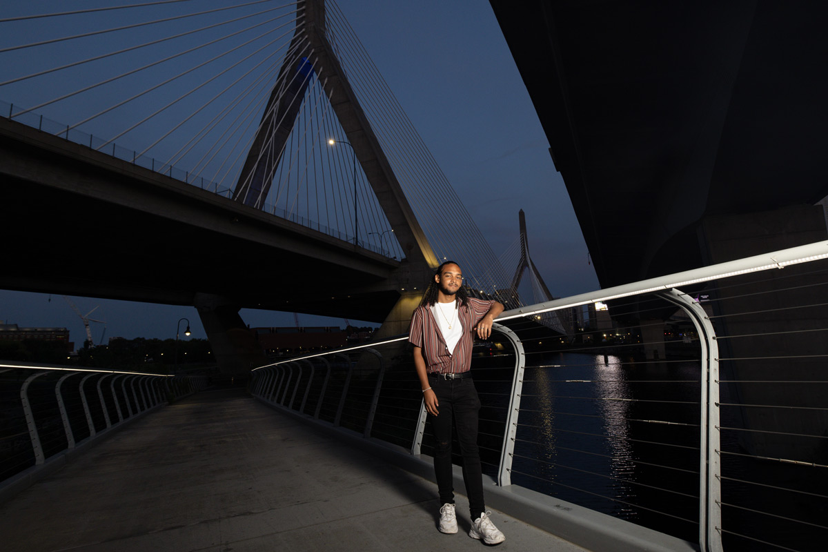 Suffolk student Omar poses for a portrait on the footbridge beneath the Zakim Bridge in Boston.