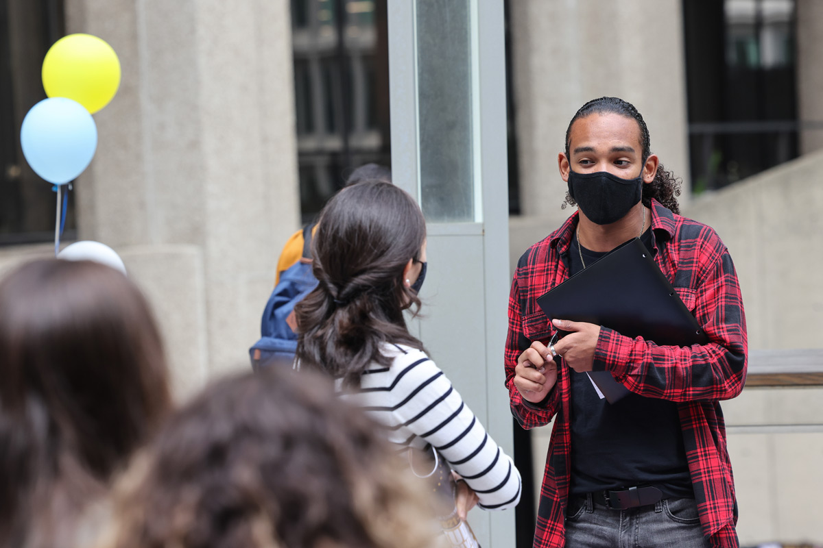 Suffolk student Omar talks with another student during the activities fair on Roemer Plaza.