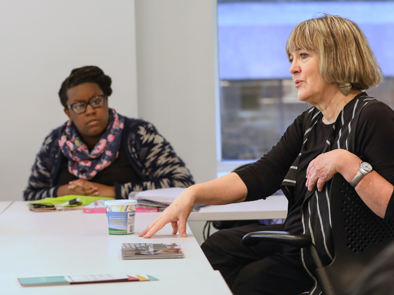 Student and a faculty member sit and talk