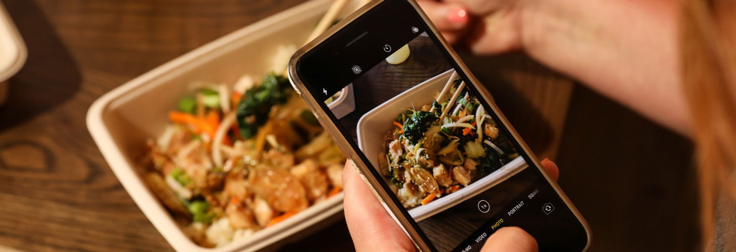 Taking a picture of her meal with an iPhone