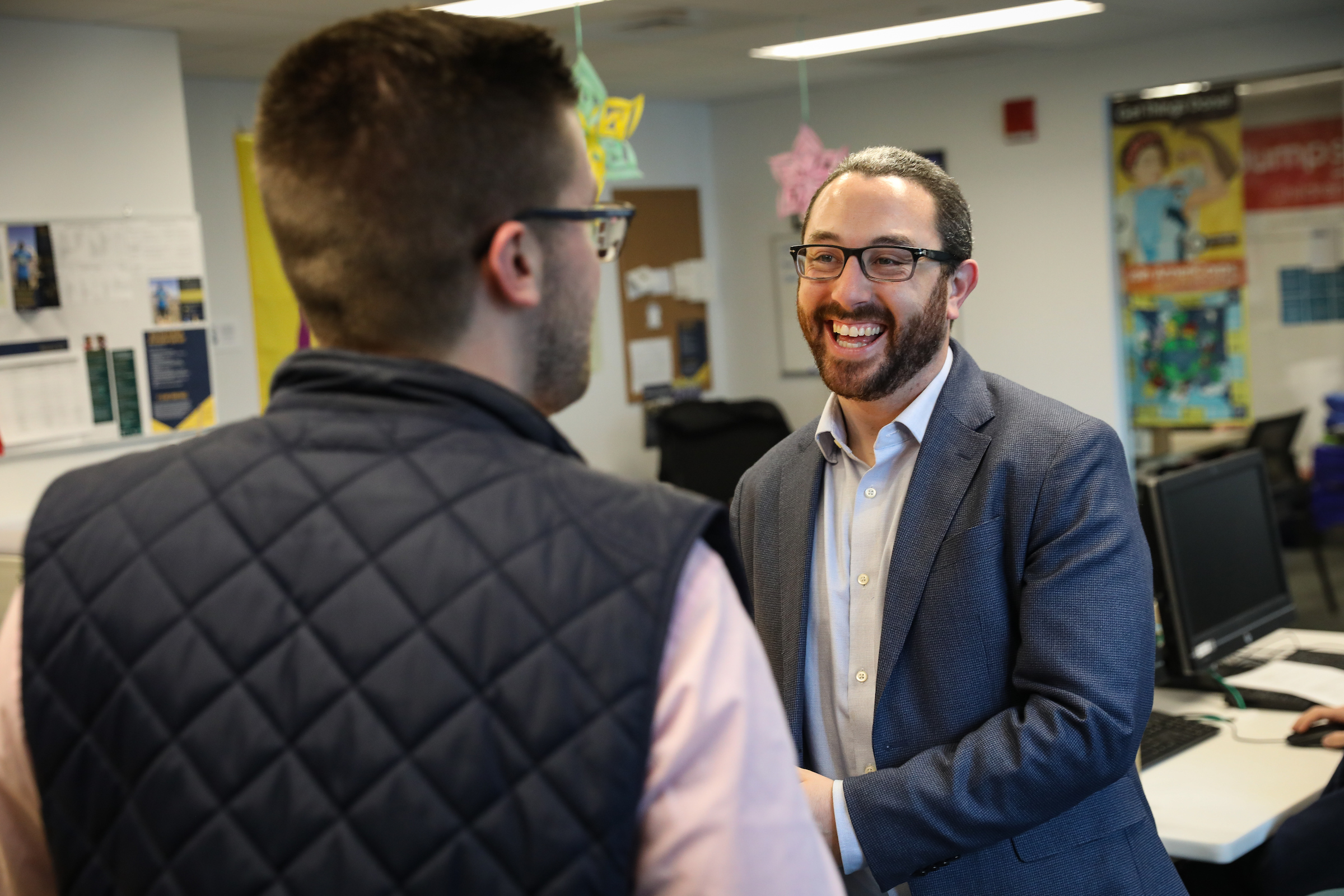 Center for Community Engagement Director Adam Westbrook talks to a colleague in his office.