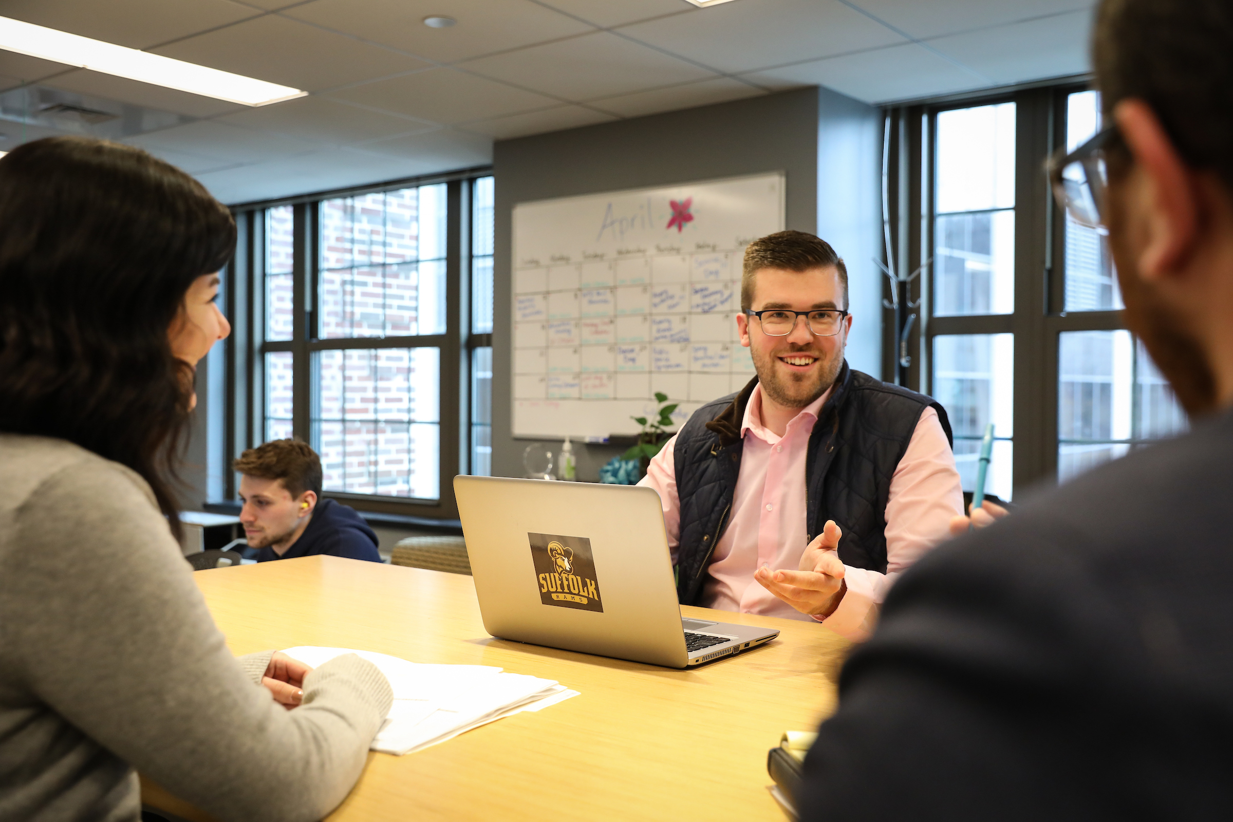 Center for Community Engagement Assistant Director Dennis Harkins sitting at a table in his office talking with colleagues.