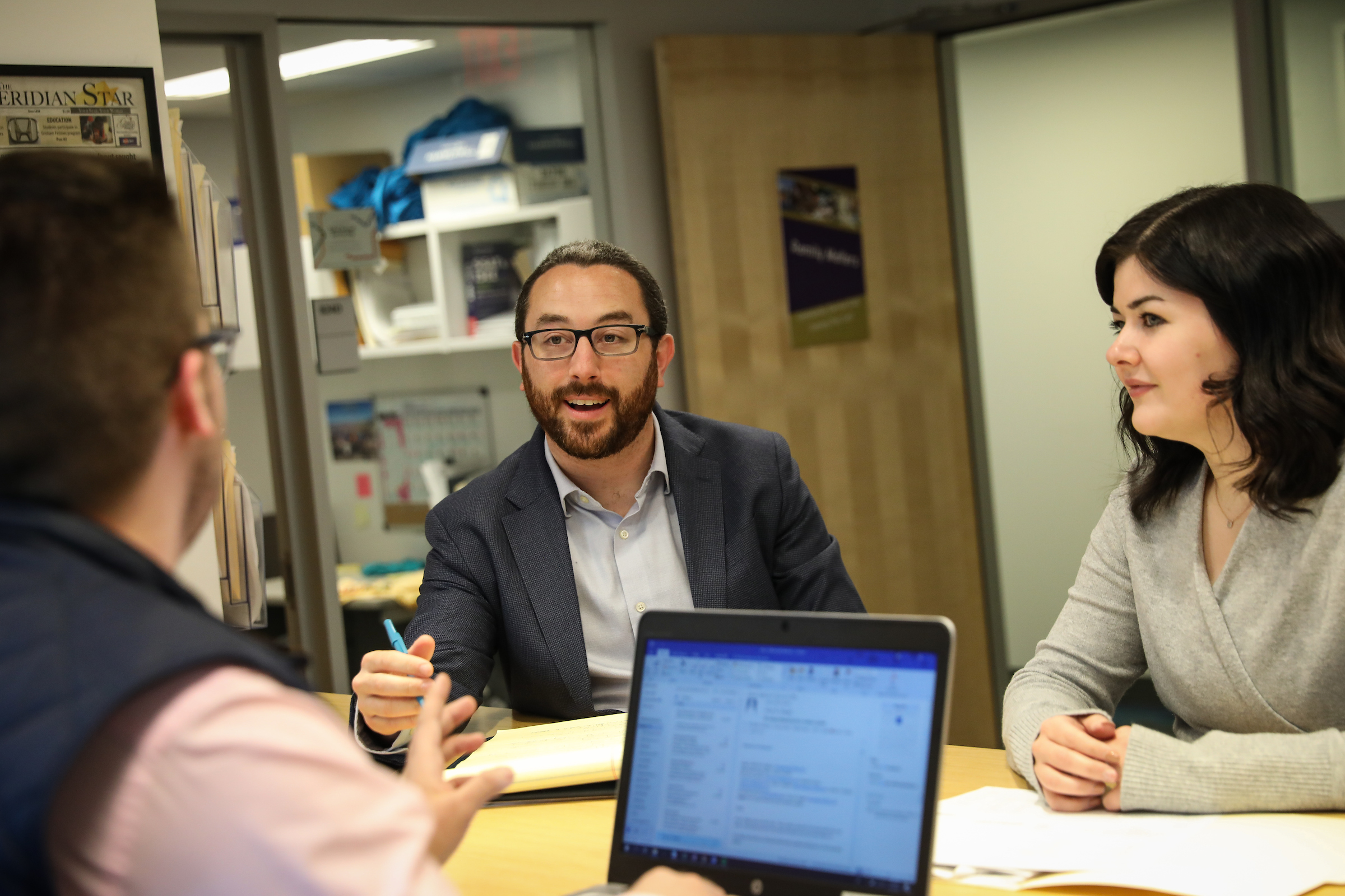 Adam Westbrook sits with fellow CCE staff in their office in the Sawyer building.