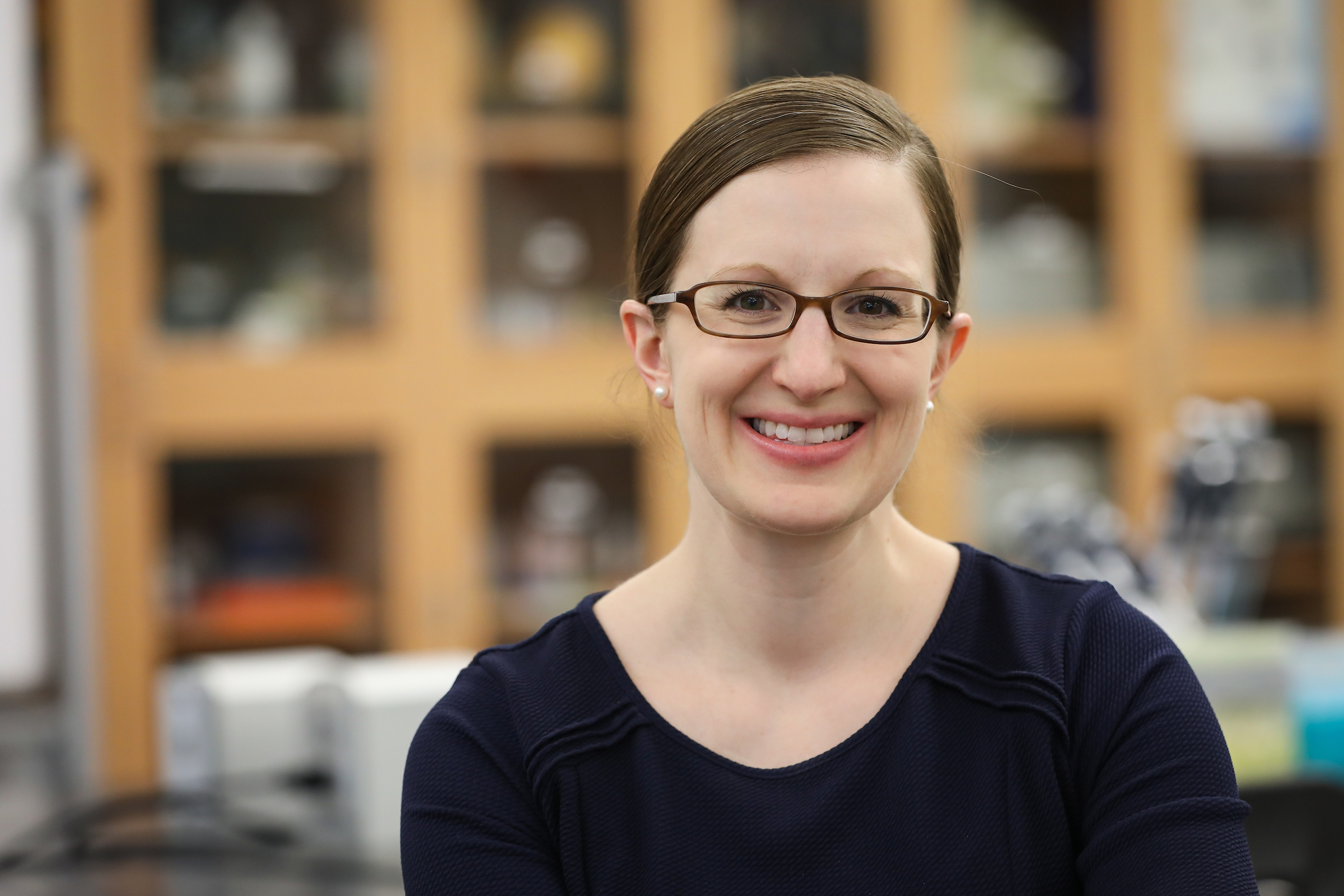 Professor of Biology and Director of Radiation Science and Therapy Jessica Mak poses for a photo in a biology lab.