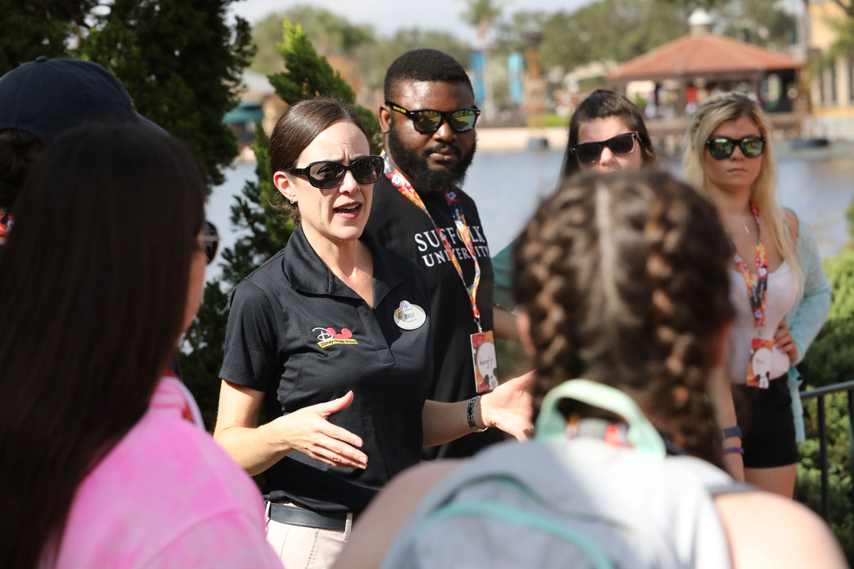 Suffolk Journey students gathered around a Disney World employee listening for instructions for the day.