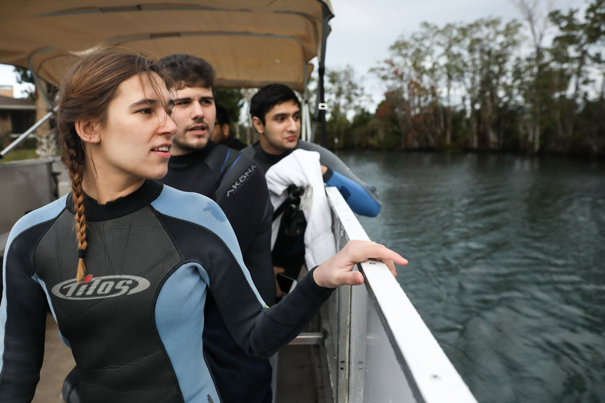 Suffolk Journey students looking out at Crystal River from a boat before swimming with manatees.