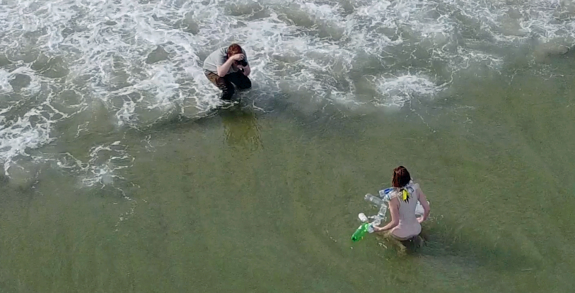 Photographer taking a picture of model on shore line