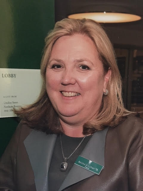 Head shot of a blonde woman in a suit
