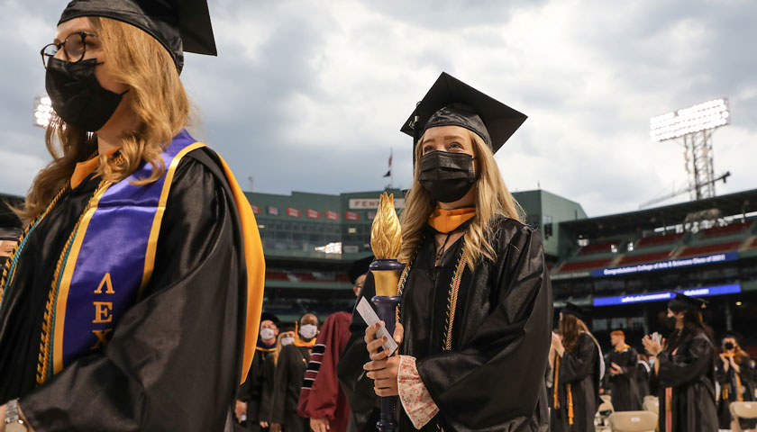 Suffolk graduates filing in to Fenway Park during the 2021 Commencement ceremony.