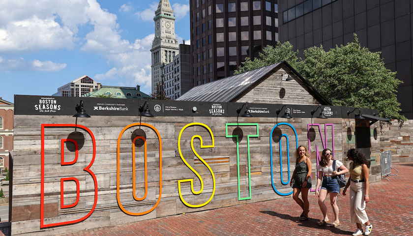 Suffolk students walk past the Boston sign in Government Center.