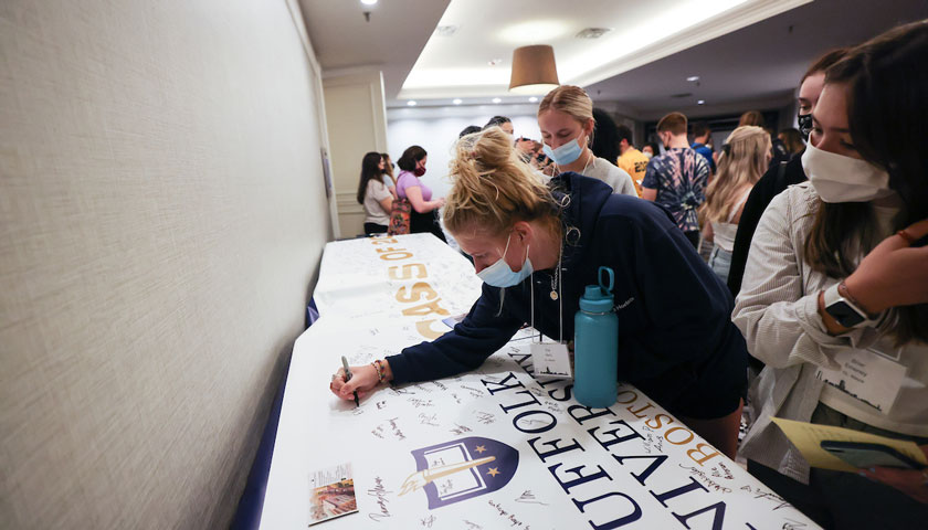 New Suffolk students sign the class banner during orientation.
